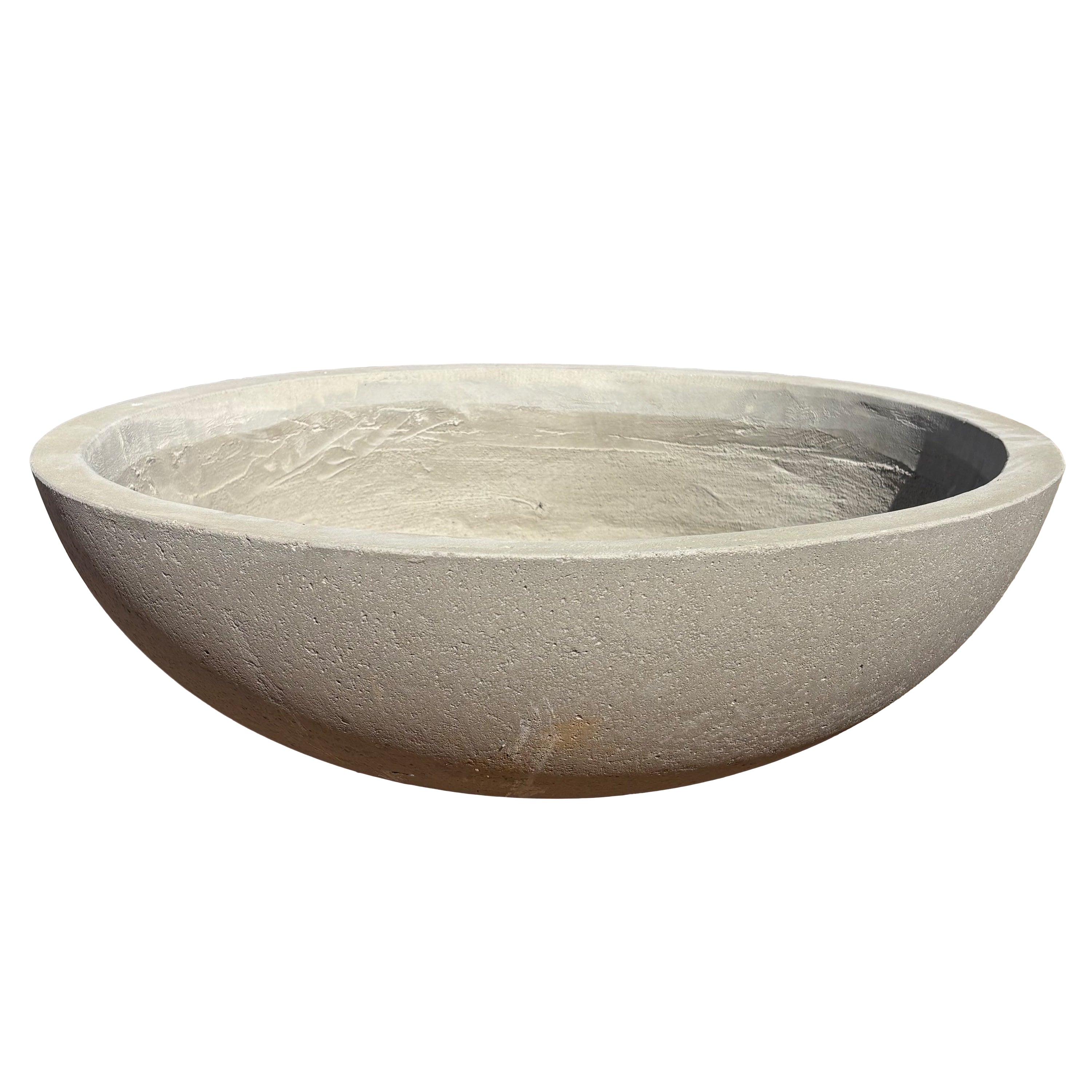 Grey low bowl fiberstone planter viewed from the front with a slight angle, emphasizing its low, rounded form and natural stone-look texture.