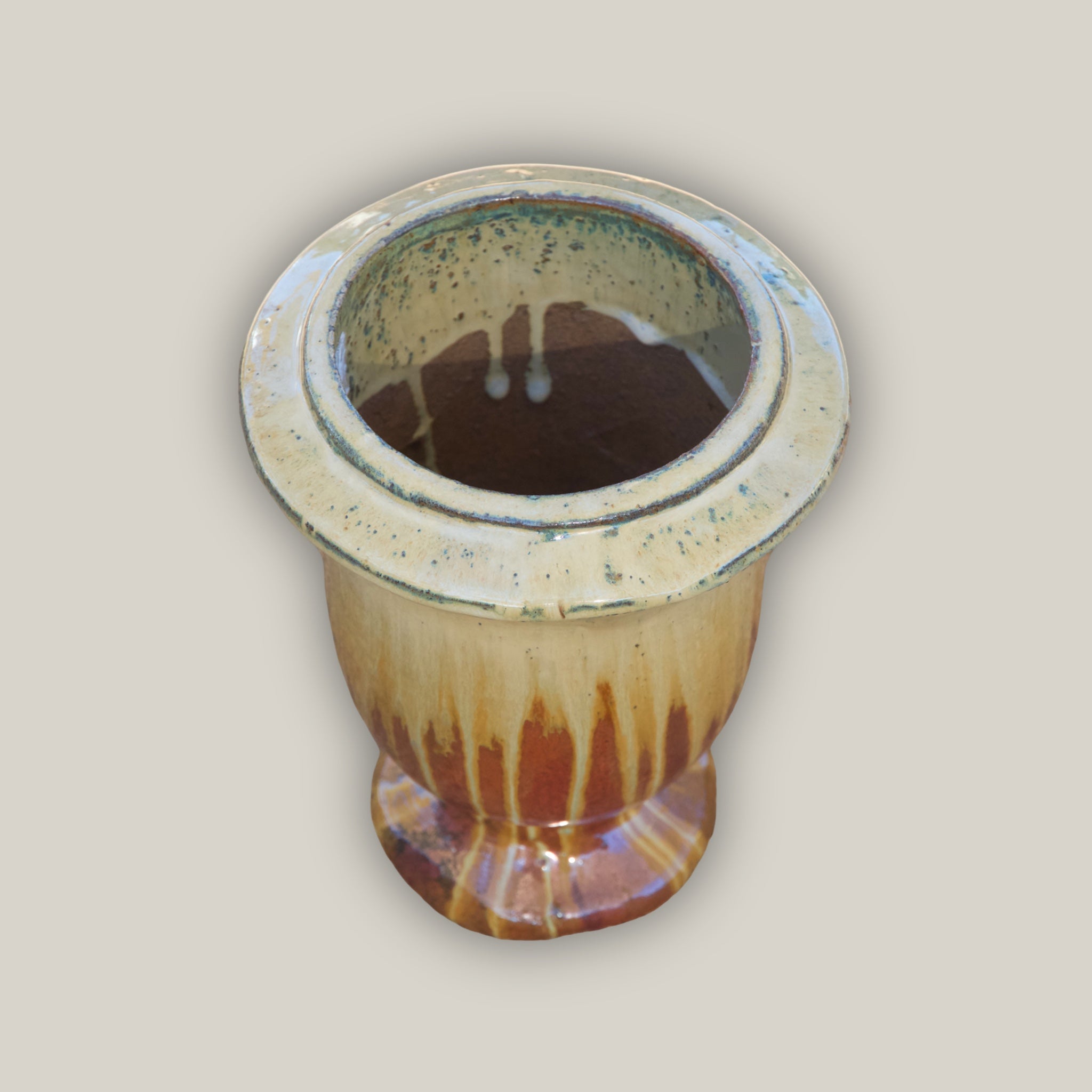 Angled view of Copper urn planter with cream dripping effect