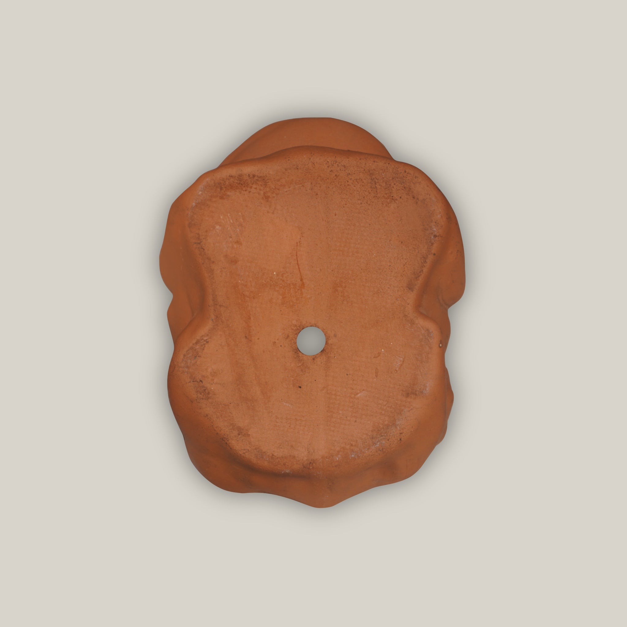Bottom of Terra cotta frog figurine with rustic clay finish