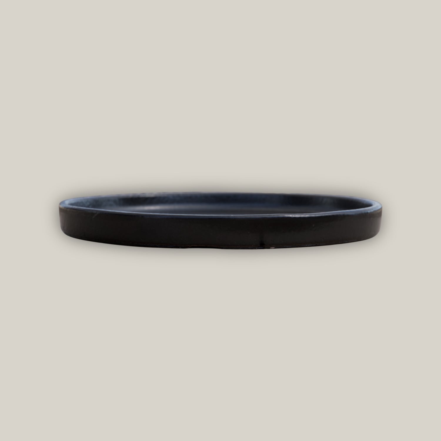 Side view of Round black ceramic plant saucer