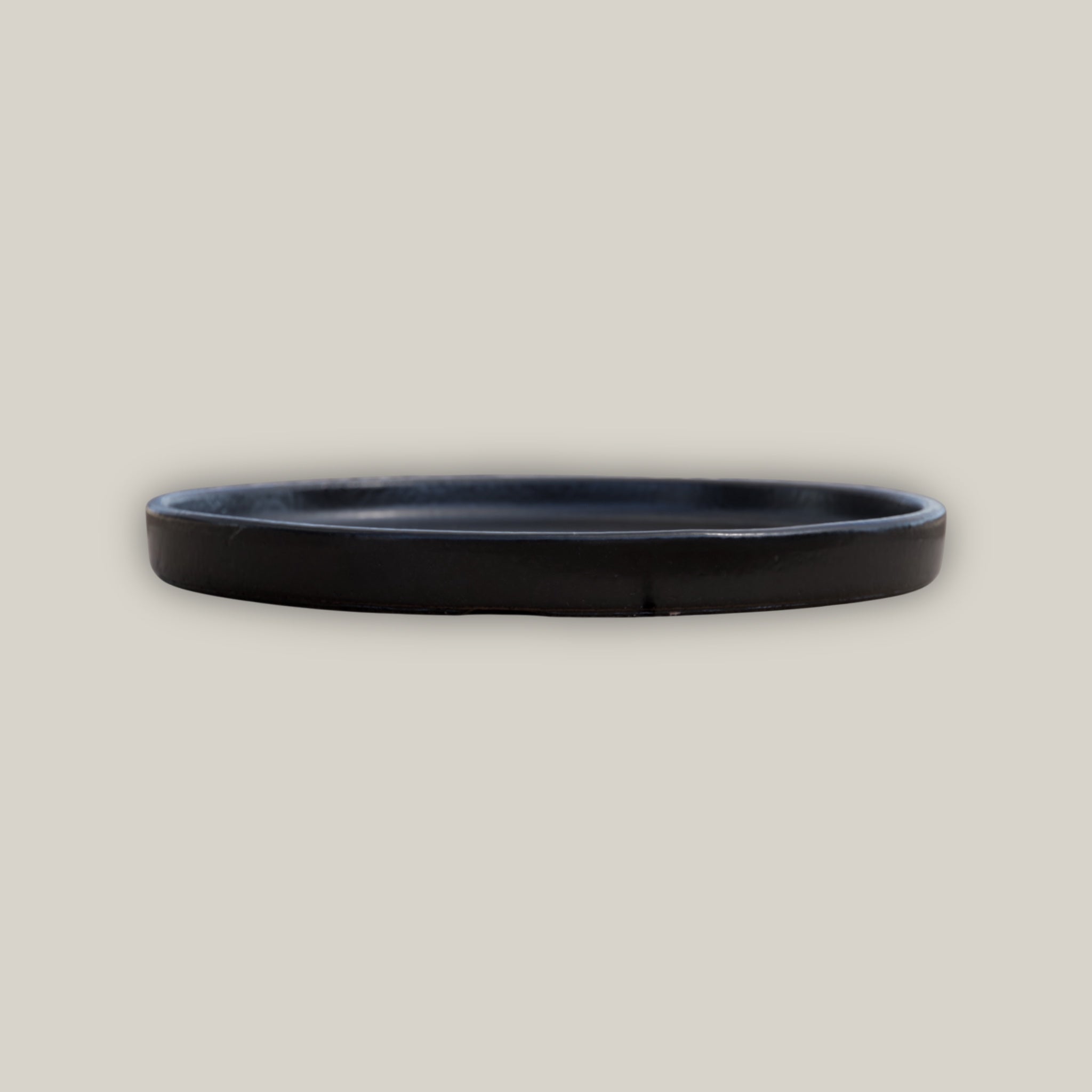 Side view of Round black ceramic plant saucer