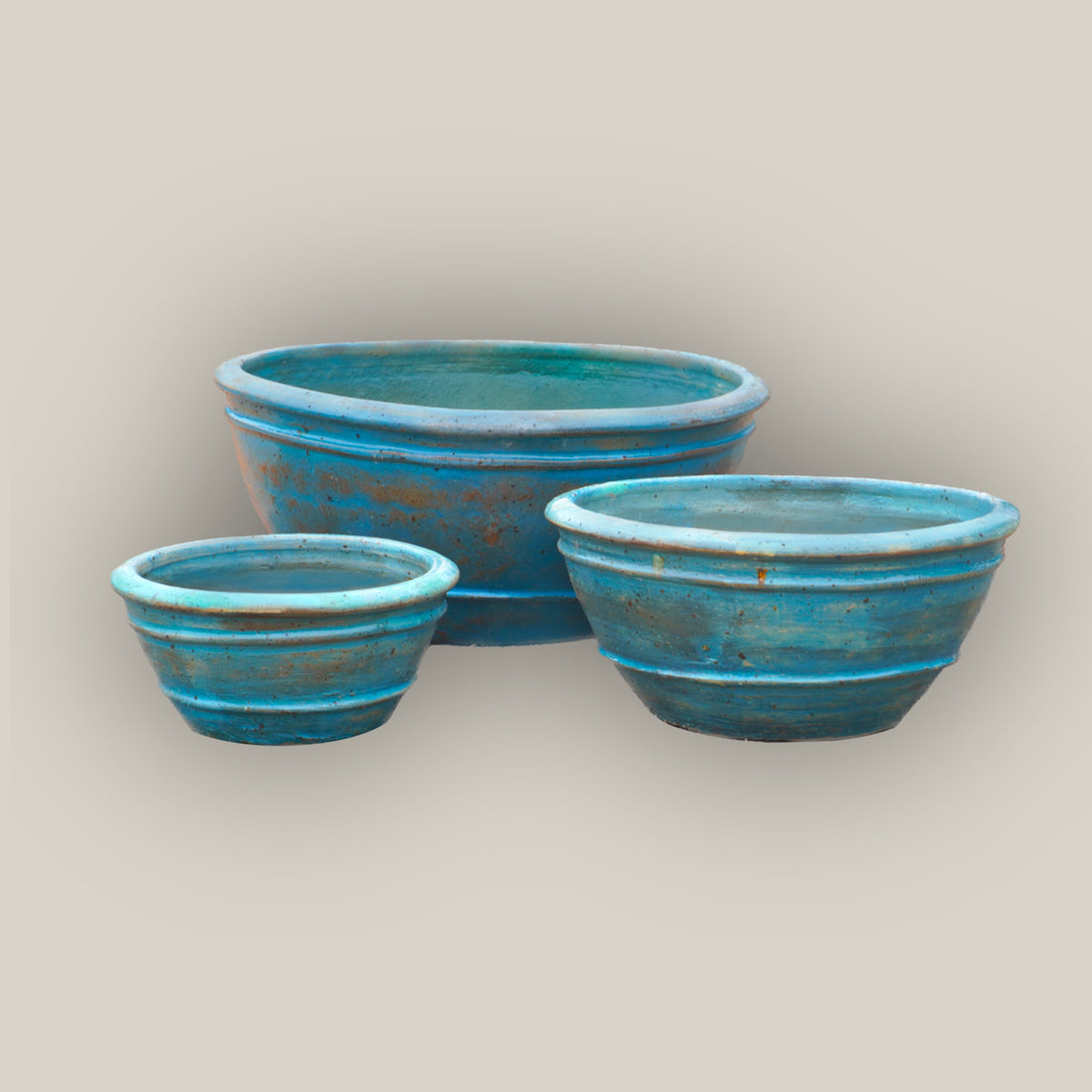 Rustic aqua bowl planters in three sizes, slightly angled, with the large bowl in back and the small and medium side by side in front.