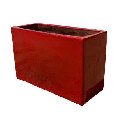 Bright red glazed rectangular ceramic planter shown from an angled side view, showcasing its depth and glossy finish.
