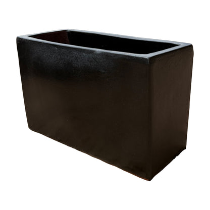 Matte black glazed rectangular ceramic planter shown from an angled side view, emphasizing its depth and refined surface texture.