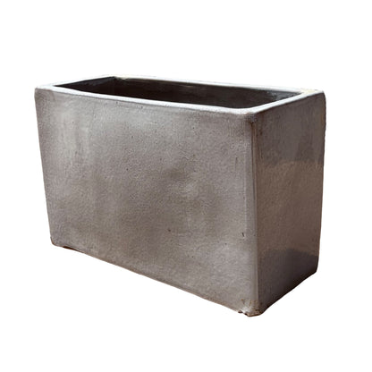 White glazed rectangular ceramic planter shown from an angled side view, emphasizing its depth and refined glazed surface.