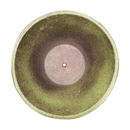 A top-down view of a round ceramic bowl planter with a textured glaze that transitions from olive green to earthy brown, featuring a small drainage hole in the center.