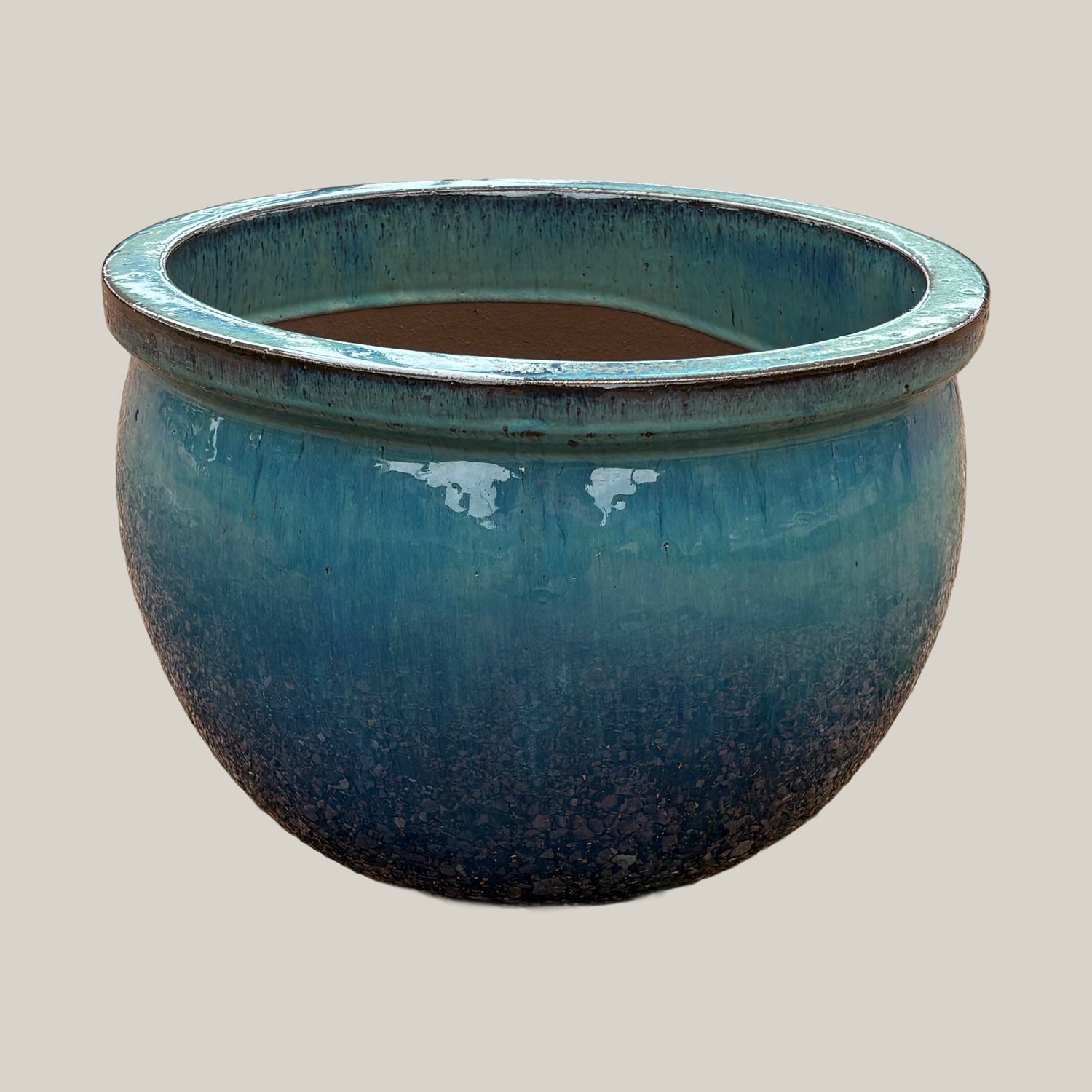 Turquoise round bowl planter with glossy glaze and wide low-profile shape, slightly angled view showing subtle color variation