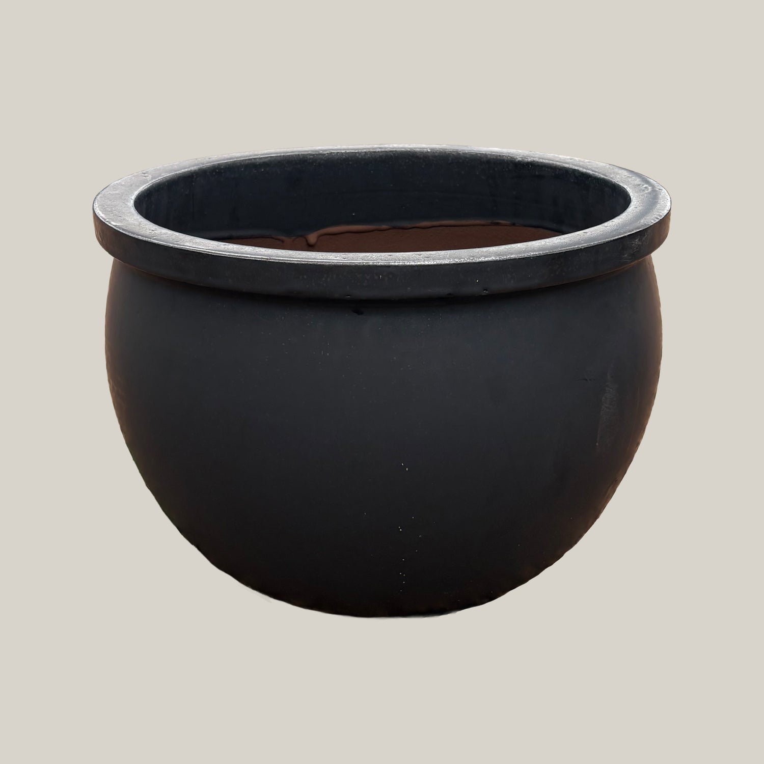 Matte black round bowl planter with wide low-profile silhouette, slightly angled view highlighting its smooth matte finish