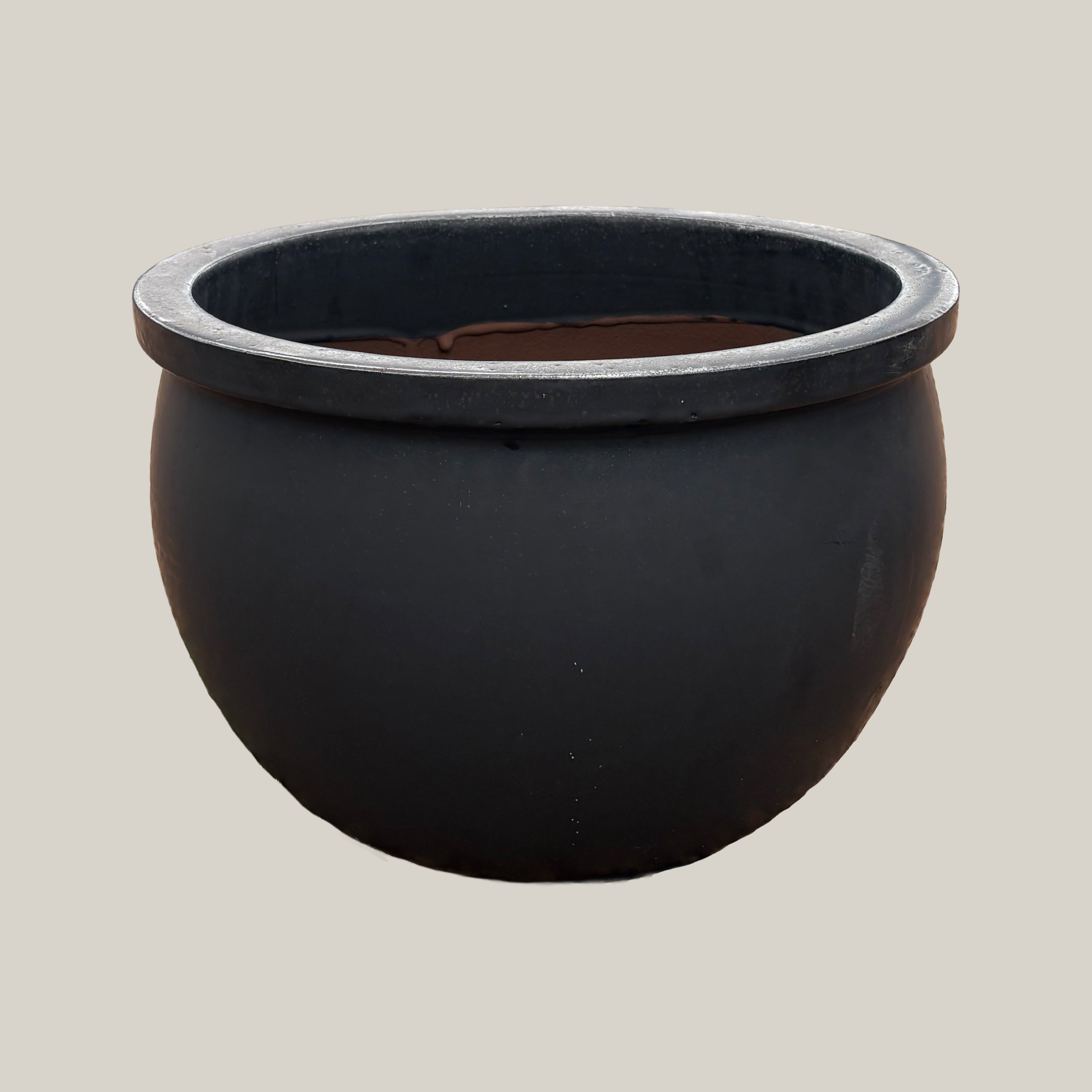 Matte black round bowl planter with wide low-profile silhouette, slightly angled view highlighting its smooth matte finish