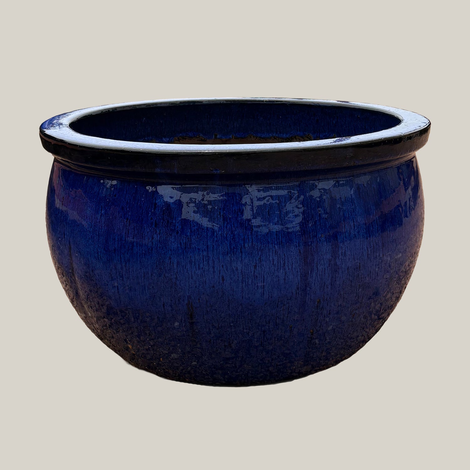 Blue round bowl planter with deep blue glazed finish, slightly angled view showing its wide silhouette