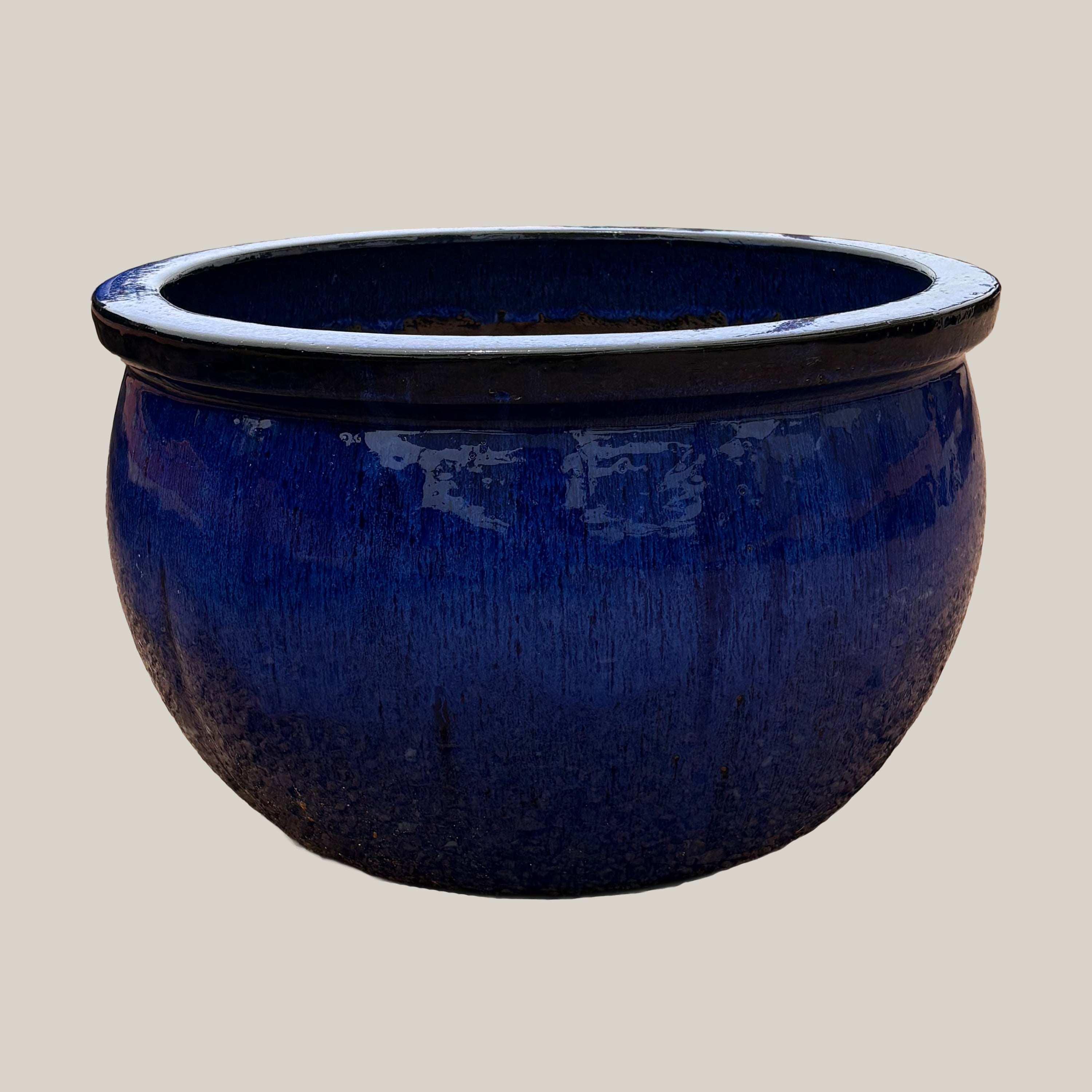 Blue round bowl planter with deep blue glazed finish, slightly angled view showing its wide silhouette