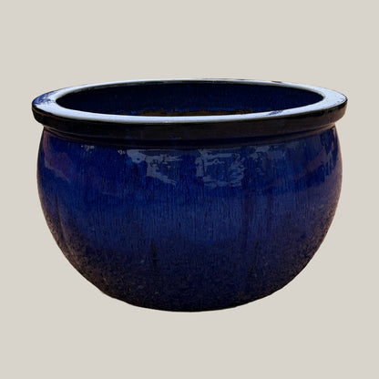 Blue round bowl planter with deep blue glazed finish, slightly angled view showing its wide silhouette