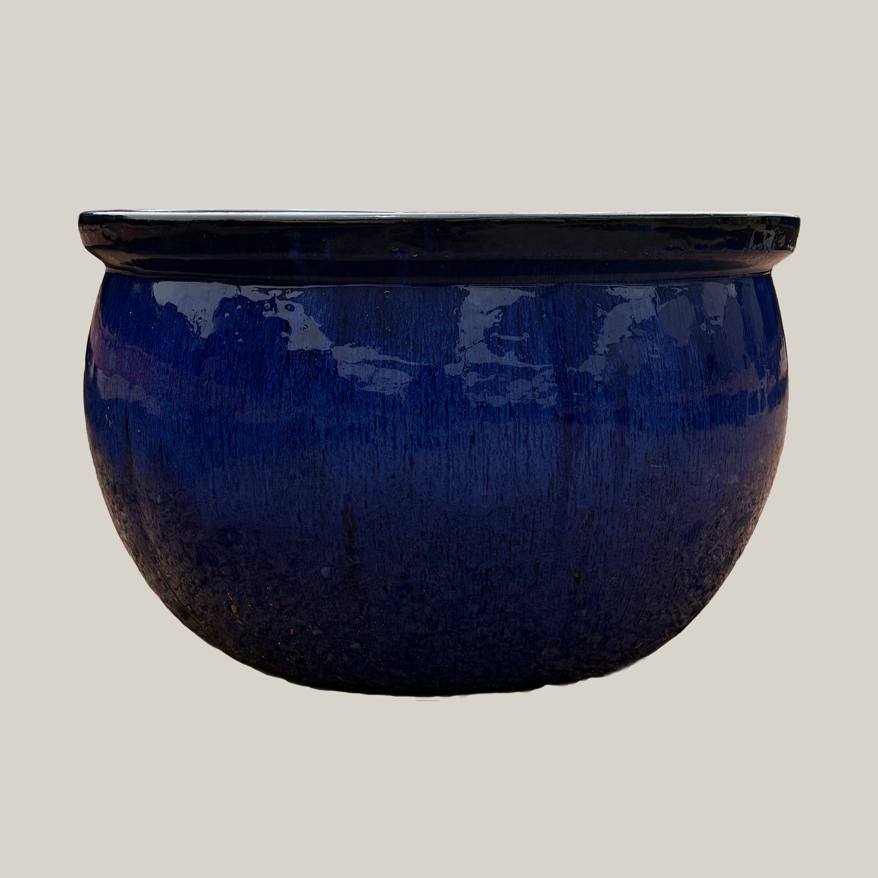 Front view of blue round bowl planter with a low-profile shape and rich glazed finish