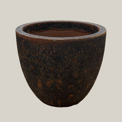 Black coral lion egg planter with rounded egg-shaped form and textured dark coral finish, slightly angled view highlighting earthy tones