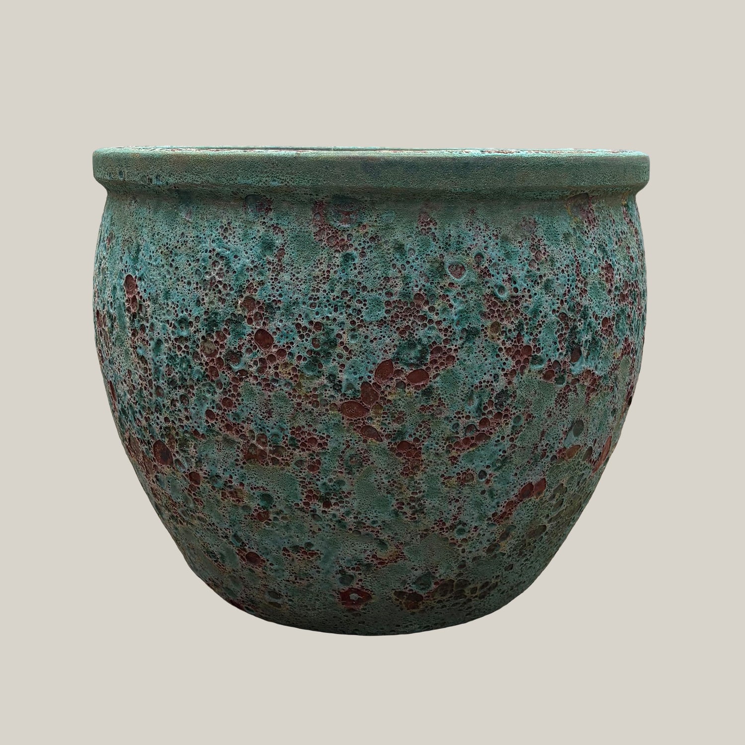 Front view of turquoise coral round low bowl planter with rounded low-profile shape and textured glaze