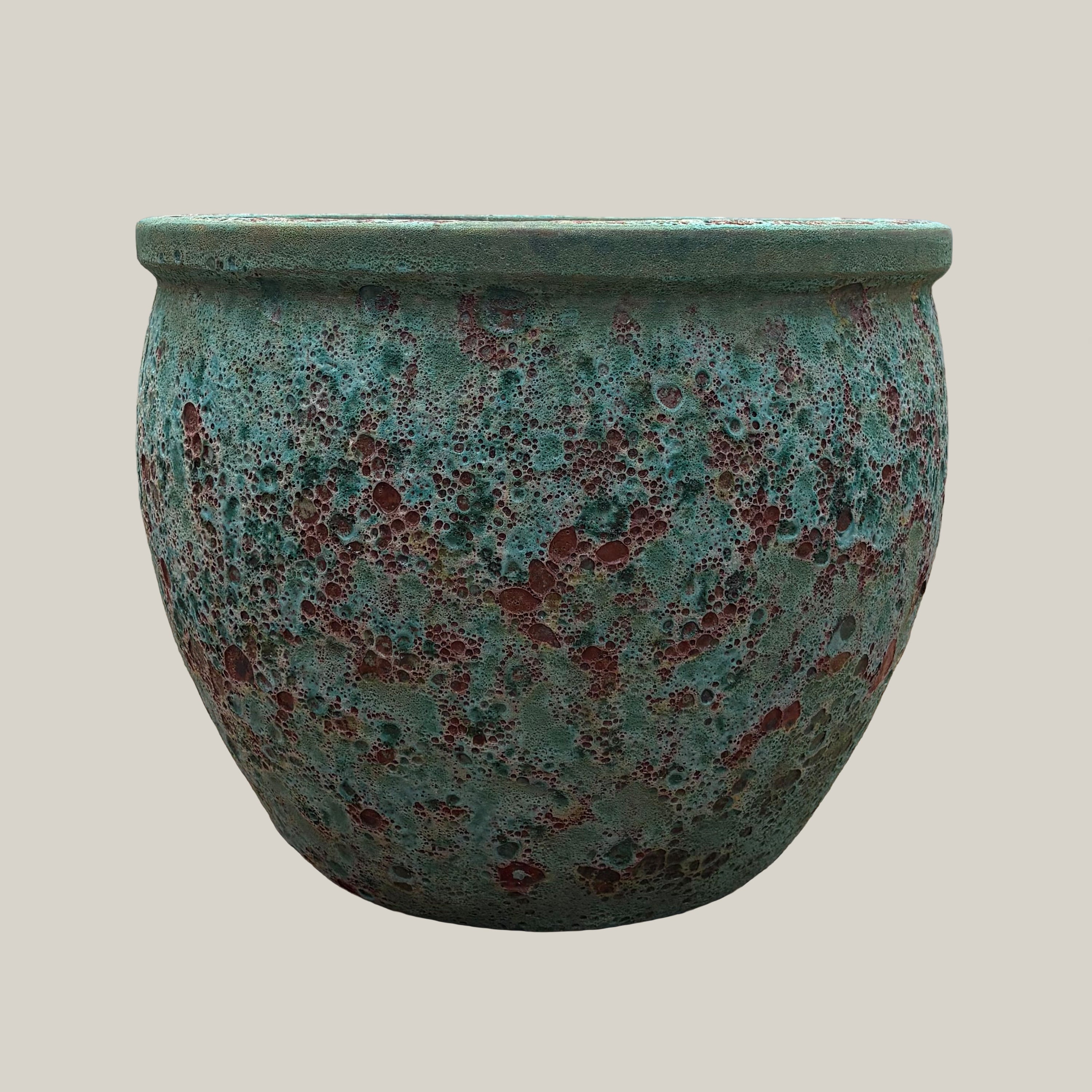 Front view of turquoise coral round low bowl planter with rounded low-profile shape and textured glaze