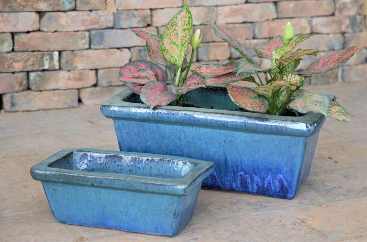 An image of two blue, ceramic pottery planters.