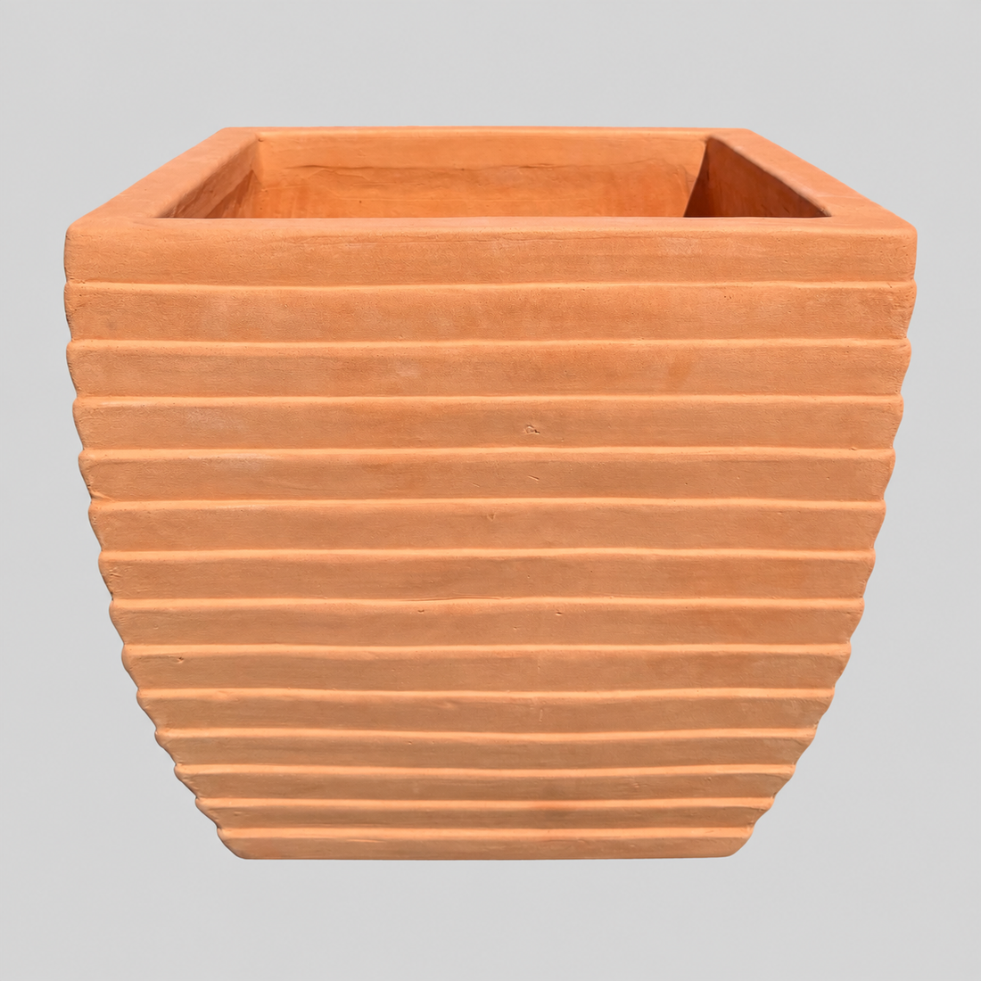 Terracotta square planter with horizontal ridges, shown against a solid gray background.
