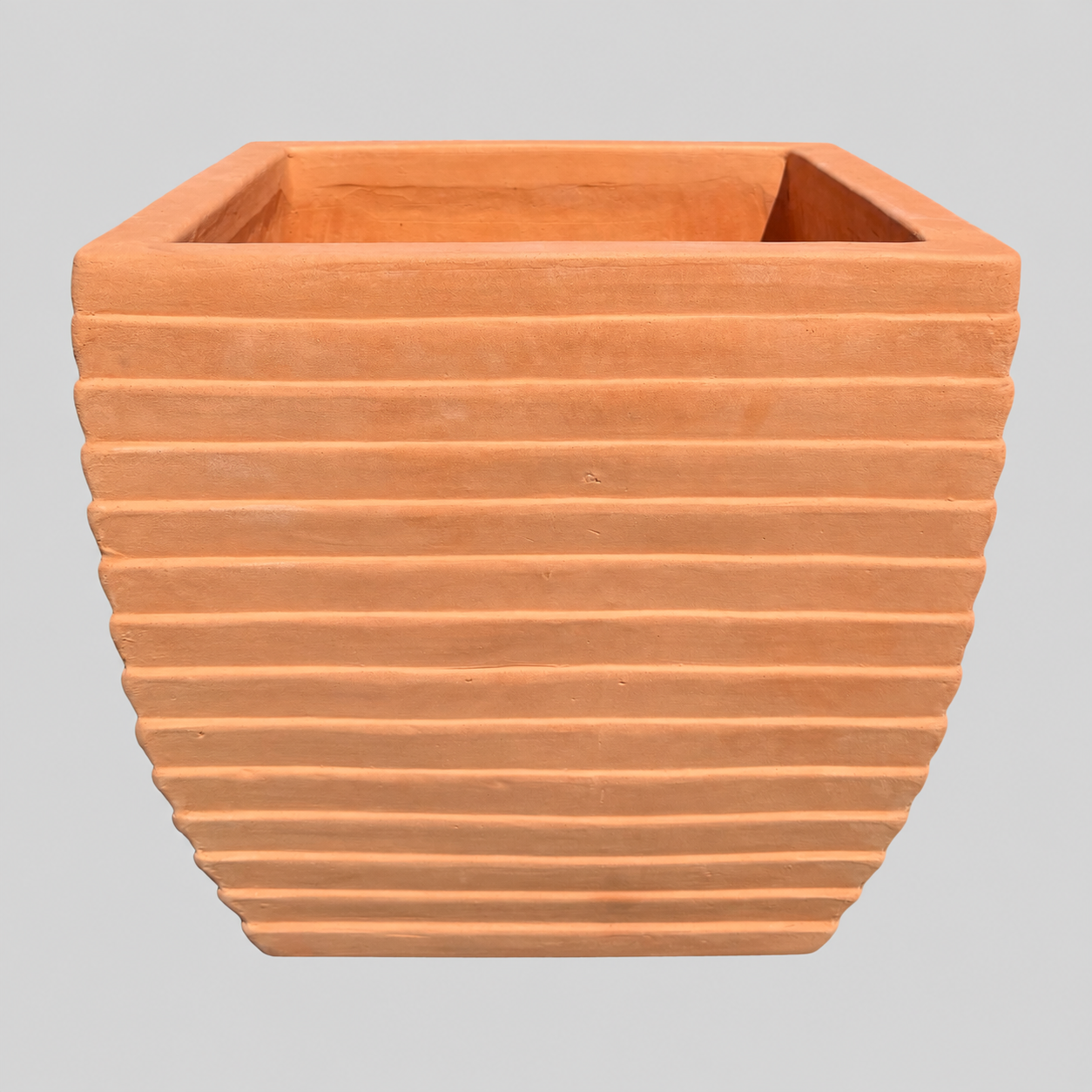 Terracotta square planter with horizontal ridges, shown against a solid gray background.