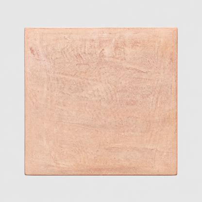A square terracotta planter with a textured, matte finish in a warm peachy-pink color, shown against a neutral light gray background.