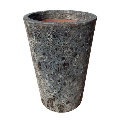 Slightly angled view of a tall, tapered planter with a highly textured, porous, and bubbled surface resembling volcanic rock, shown against a plain white background.