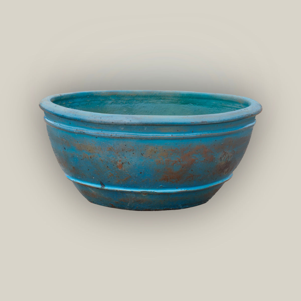 Antique Aqua rustic low bowl ceramic planter, slightly angled from above to show its rolled rim, raised rings, and aqua glaze.