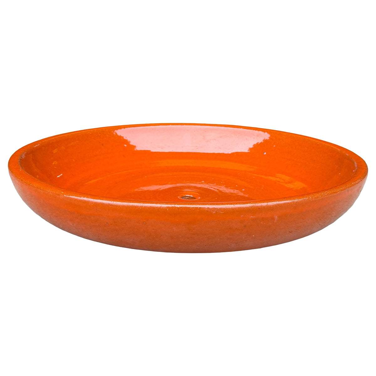 Angled view of a wide, shallow atomic orange ceramic succulent bowl with a glossy vivid orange interior, a neat rounded rim and a central drainage hole