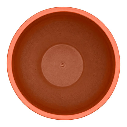 Top-down view of an atomic orange tapered round ceramic planter, with a coral-orange rim, warm orange inner walls and a raised circular floor with a small drainage hole at the center