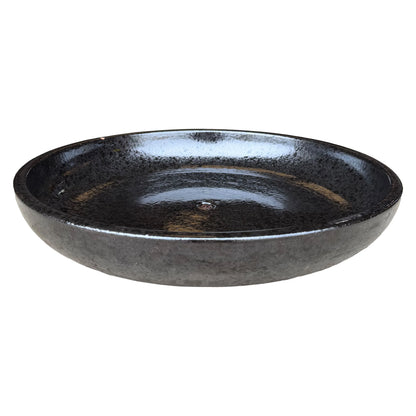 Angled view of a wide, shallow black ceramic succulent bowl, showing a high-gloss speckled black interior, a central drainage hole and a charcoal outer wall