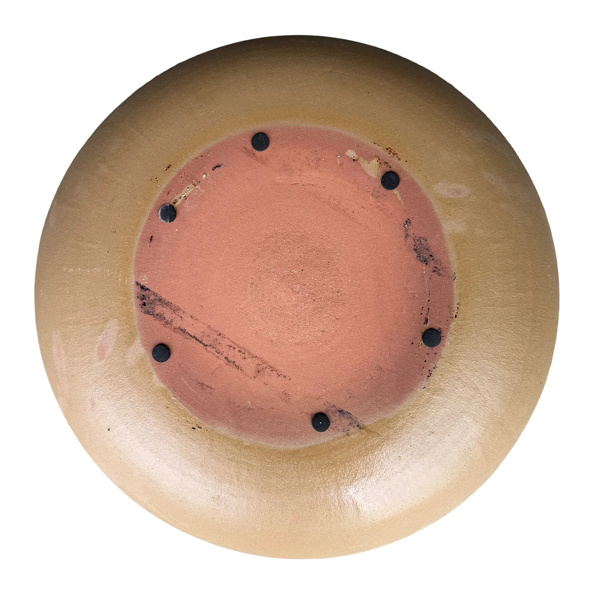 Underside of a Yellow Spray ceramic bird bath bowl, with an unglazed terracotta base, six small dark pads, and a tan glazed rim.
