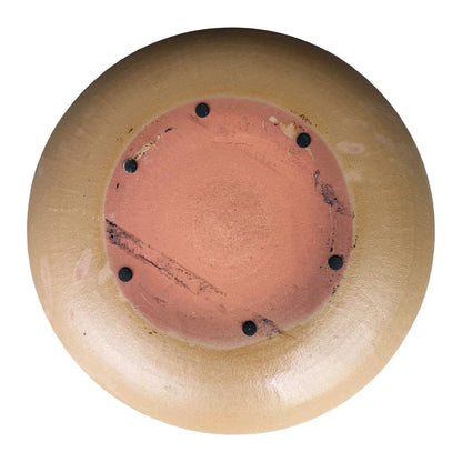 Underside of a Yellow Spray ceramic bird bath bowl, with an unglazed terracotta base, six small dark pads, and a tan glazed rim.