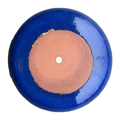 Underside of a Falling Blue ceramic succulent bowl, with an unglazed terracotta base, a center drainage hole, and a glossy blue glaze around it.