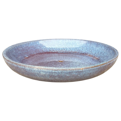 Angled view of a wide, shallow falling purple ceramic succulent bowl with periwinkle walls, a plum-toned base around the drainage hole and a speckled rim