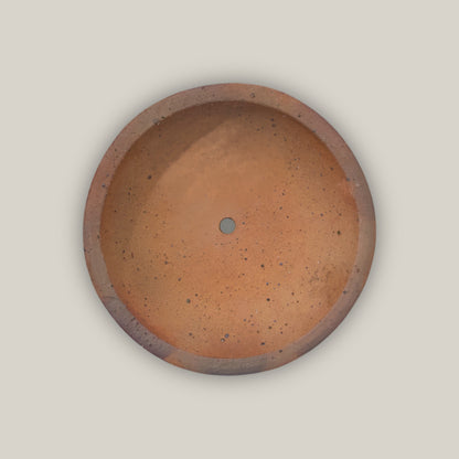 Looking straight down into the Iron Clay Rustic Style Wide Bowl, its smooth terracotta basin and central drainage hole are framed by a thick, earthy clay rim.