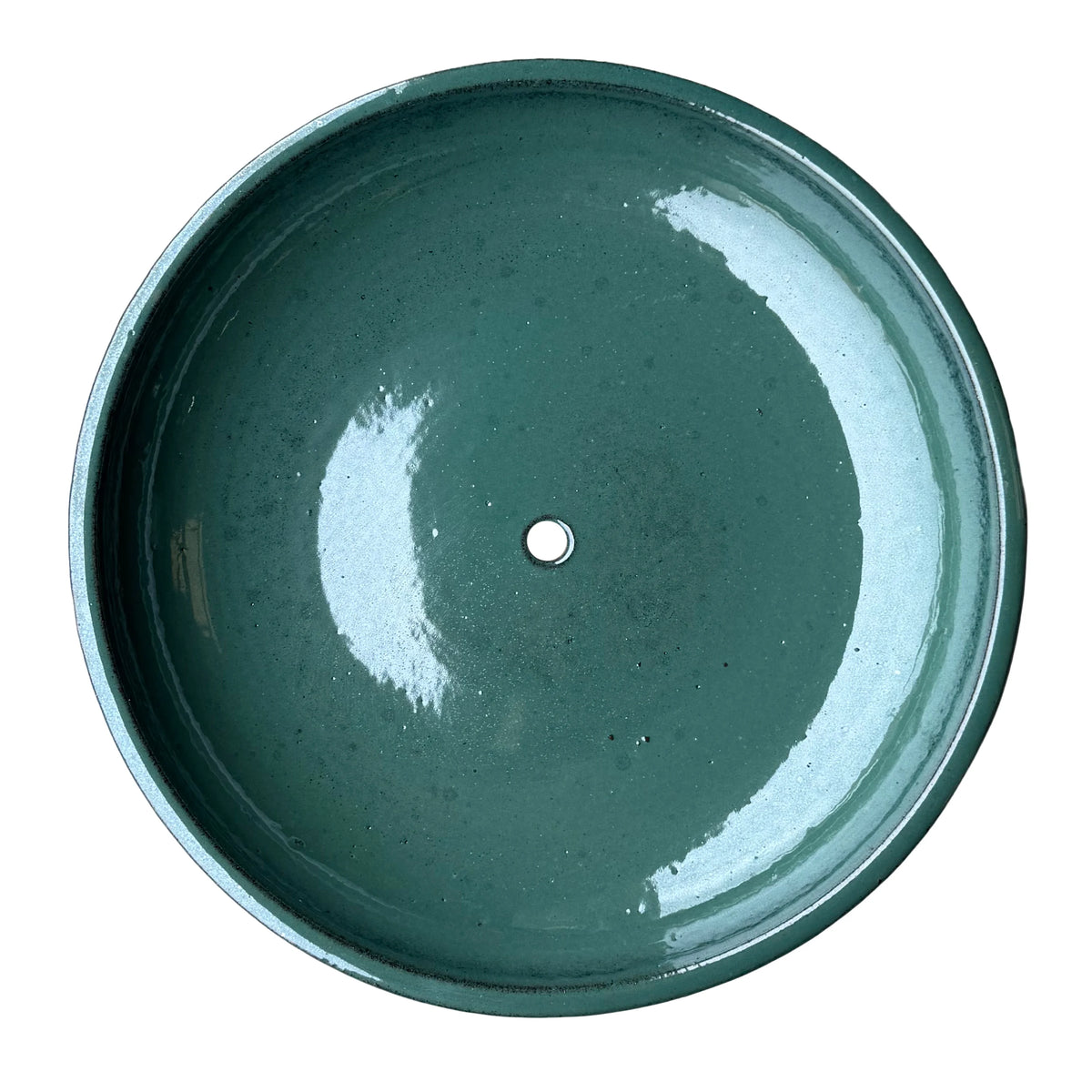 Top-down view of a jade ceramic succulent bowl, showing a wide, glossy deep green basin with a single drainage hole in the center.