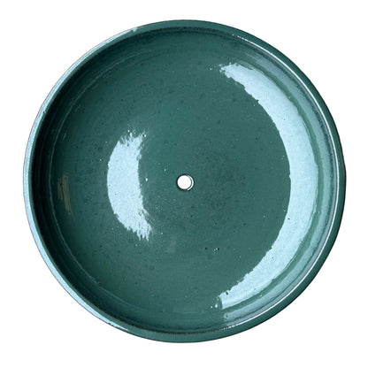Top-down view of a jade ceramic succulent bowl, showing a wide, glossy deep green basin with a single drainage hole in the center.