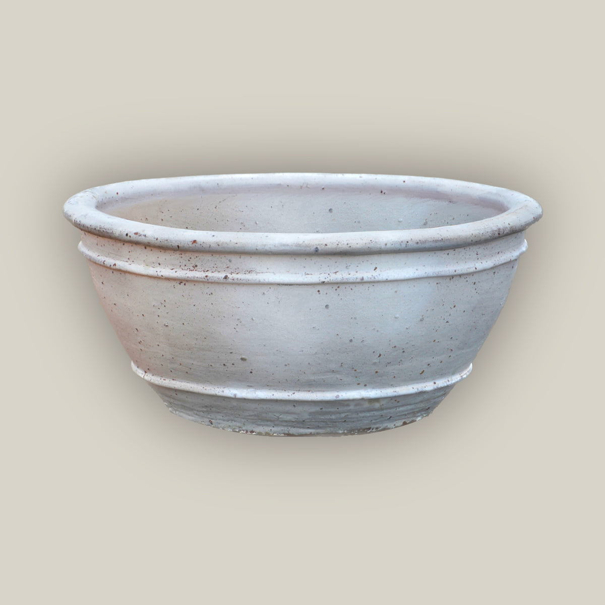 Matte White rustic low bowl ceramic planter, slightly angled from above to show its rolled rim, raised rings, and speckled finish.