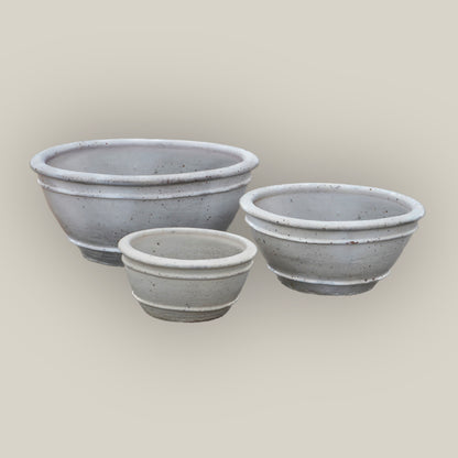Speckled off-white bowl planters in three sizes, slightly angled from above, with the large bowl left, medium right, and small in front.