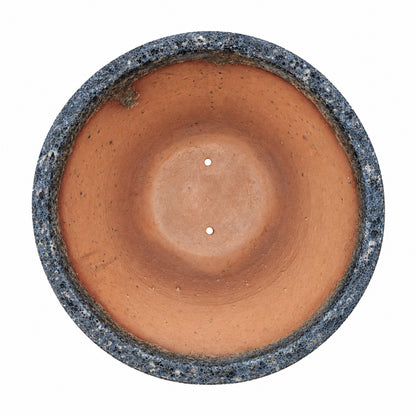 A top-down look into the Relic Rust/Metal Blue Giant Cone Ceramic Planter, its sun-warmed terracotta interior framed by a rugged, pitted blue-grey rim.