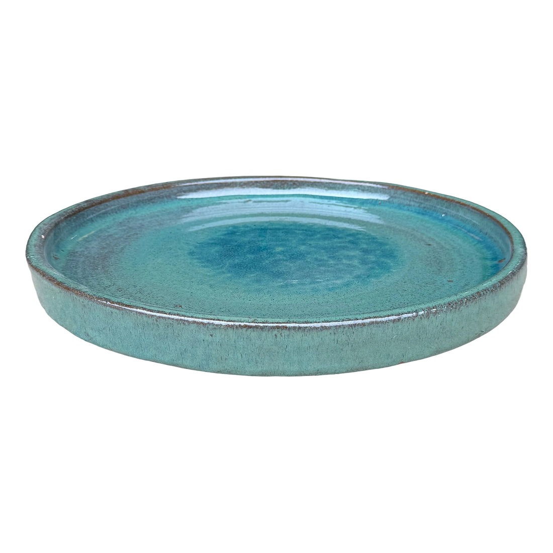 Angled view of a wide, shallow round teal ceramic plant saucer with a glossy speckled interior, a deeper blue centre and a flecked rim