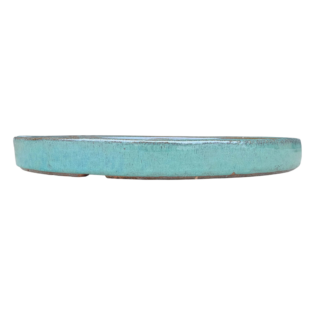 Front view of a round teal ceramic plant saucer, showing its low straight wall in a streaky aqua-teal glaze with warm brown clay peeking through at the rim and base