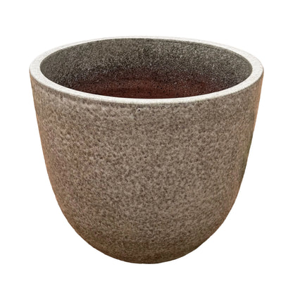 Angled view of a speckle black tapered round ceramic planter, showing its stone-textured speckled exterior, a lighter speckled rim and a darker speckled interior