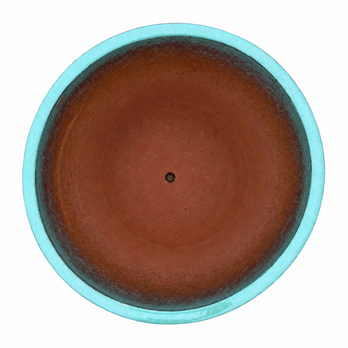 Top-down view of a teal tapered round ceramic planter, with a bright aqua rim and teal inner walls that fade into a terracotta-red floor with a small central drainage hole